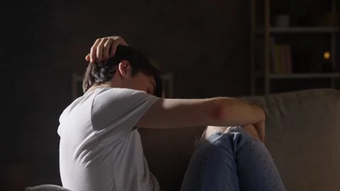 Sad teenager boy sitting on sofa Stock Footage 246421753