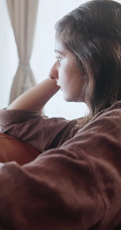 Sad, thinking and window with woman on sofa in home for regret, grief memory and Stock Footage 337499485