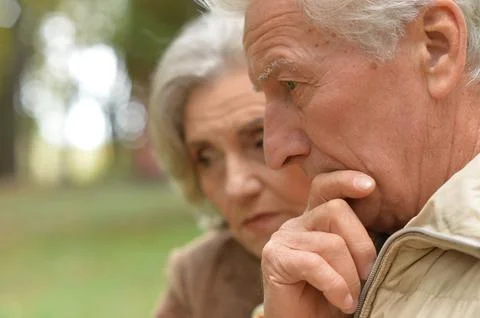 Sad thoughtful old nice couple in park Stock Photos