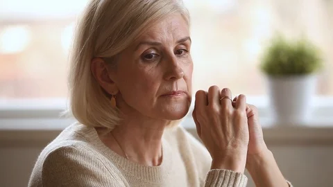 Sad thoughtful senior woman feeling lonely worried about problems Stock Footage