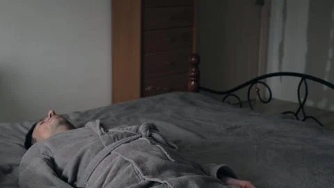 Sad tired man falling on bed after stressful day, burnout  exhaustion Видео 332055721
