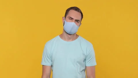 Sad tired young man in basic casual blue t-shirt sterile face mask showing Stock Footage 148292258