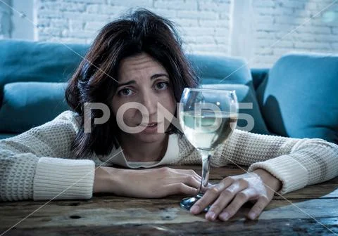 Sad, unhappy, helpless woman drinking wine alone at home. Human emotions, dep Stock Photos