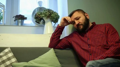 Sad, unhappy man with beard sitting in cafe  Video stock 70859933