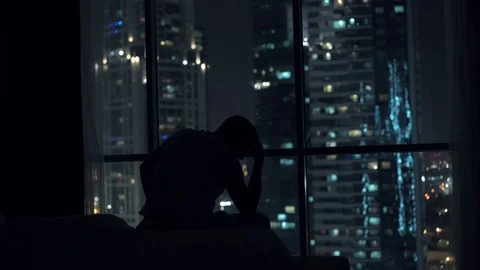 Sad, unhappy man standing by window during night, 4K Stock Footage 70356780