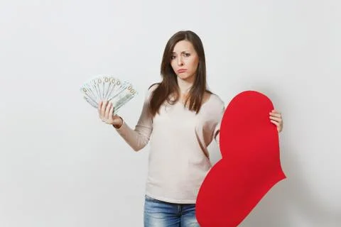 Sad upset lamentable woman holding big red heart, bundle of cash money dollars Stock Photos
