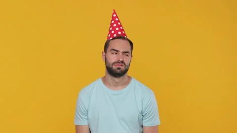 Sad upset serious fun young man 20s years old in birthday hat basic casual blue Stock Footage 148291943