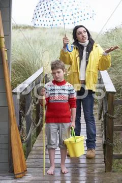 Sad woman and child with umbrella Stock Photos