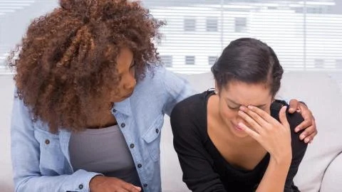 Sad woman crying next to her therapist Stock Photos