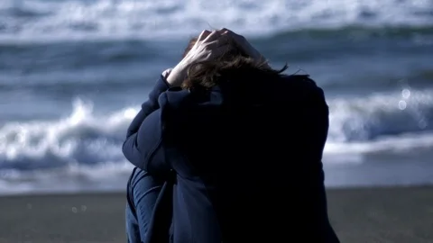 Sad woman in front of the ocean turning around looking camera slow motion Stock Footage 116735853