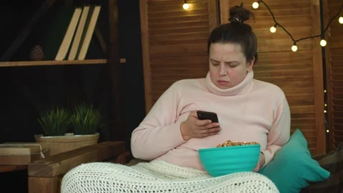 Sad woman, waiting for a  message, checking her phone after licking her fingers Stock Footage 147036617