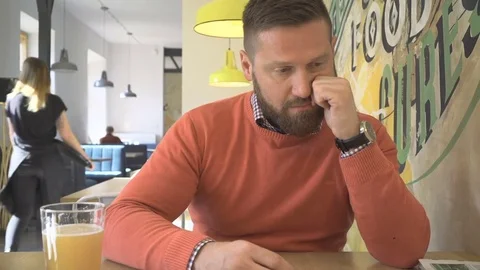 Sad, worried man sitting at table, portrait, in pub, cafe, indoor, steadicam 库存影片 73229975