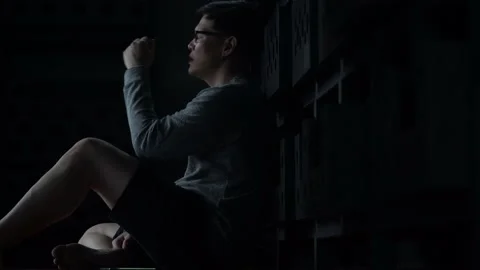 Sad young asian man sitting on the floor checking mobile phone with bad news Stock Footage 158794700