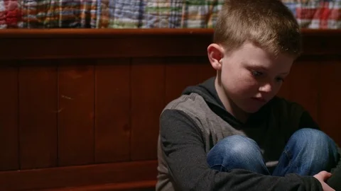 Sad young boy sitting in his room alone Video stock 70709724