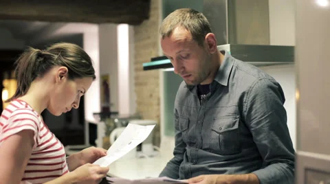 Sad young couple reading payment bills in the kitchen HD Stock Footage 33720305