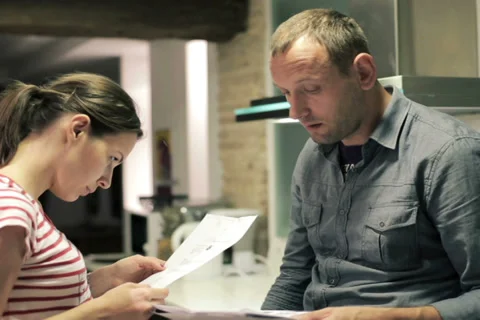 Sad young couple reading payment bills in the kitchen NTSC Vídeo Stock 33720321