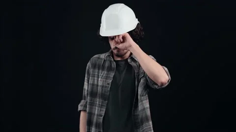 The sad young engineer, with a white helmet, isolated on a black background Stock Footage 156279670