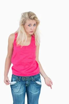 Sad young female showing her empty pockets Stock Photos