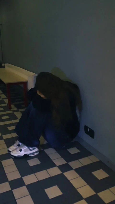 Sad young female student crying in a corner of the school hallway Stock Footage 346597948