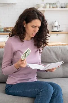 Sad young girl holding last cash money feeling anxiety about debt or bankruptcy Stock Photos