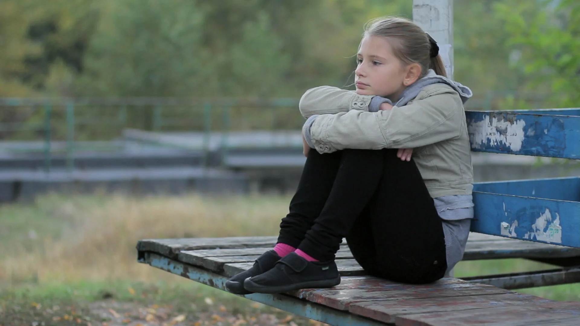 sad little girl sitting alone