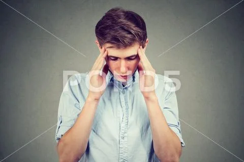Sad young handsome man with worried stressed face expression looking down Stock Photos