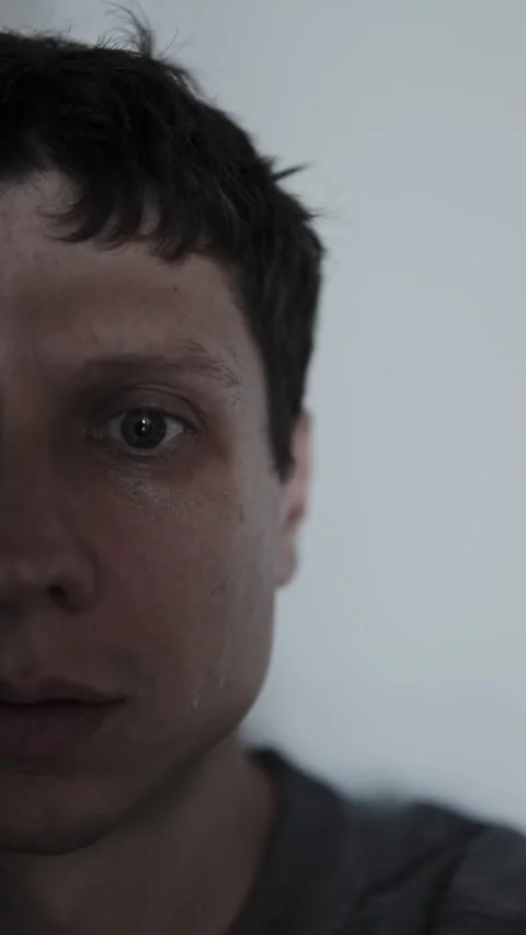 Sad young man crying alone after receiving bad news about breakup or loss Stock Footage 313879835