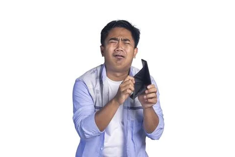 Sad young man crying while looking at his empty black wallet against a whit.. Stock Photos