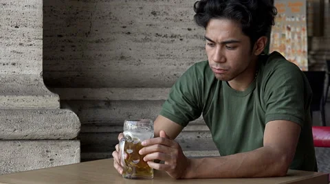 Sad young man drinking beer alone and sad: pensive depressed man  Stock Footage 66684706