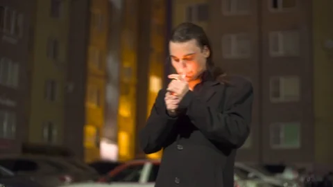 A sad Young man sets fire to a cigarette. Depression. Nervously Smoking a Stockbeeldmateriaal 90403398