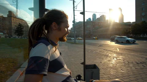 Sad young man sitting on the bus stop Stock Footage 65288382