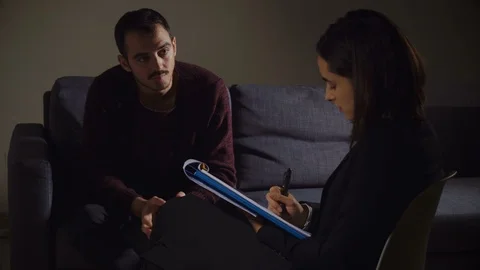  Sad young man Sitting During Therapy At Psychologist Stock Footage 100033226