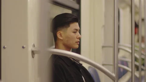 Sad Young man sitting on a moving city metro train Stock Footage 159028551