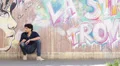 sad young man - wall with graffiti in background HD Footage