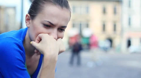 Sad young woman sitting in urban environment, close up Stock Footage