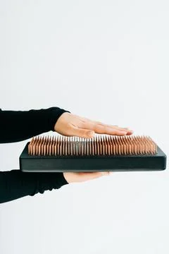 A sadhu board of their dark solid oak with copper nails, in the hands of a young Stock Photos