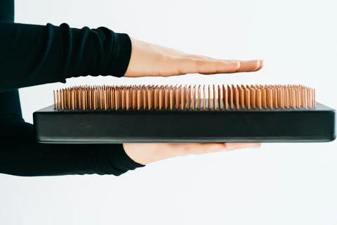 A sadhu board of their dark solid oak with copper nails, in the hands of a young Stock Photos