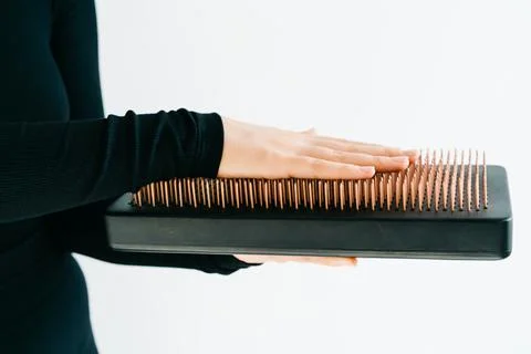 A sadhu board of their dark solid oak with copper nails, in the hands of a young Foto stock