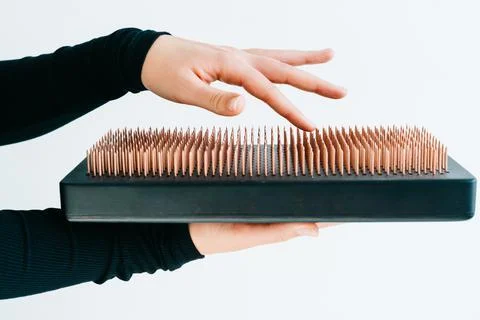 A sadhu board of their dark solid oak with copper nails, in the hands of a young Stock Photos