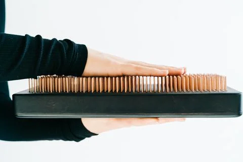 A sadhu board of their dark solid oak with copper nails, in the hands of a young Stock Photos