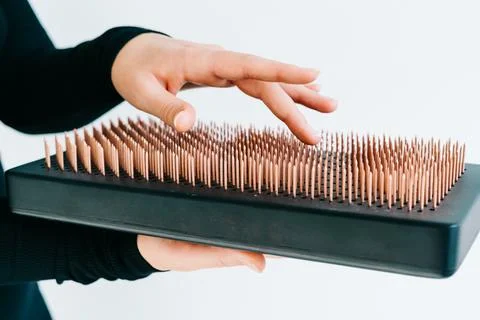 A sadhu board of their dark solid oak with copper nails, in the hands of a young Stock Photos