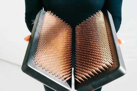 A sadhu board of their dark solid oak with copper nails, in the hands of a young Stock Photos
