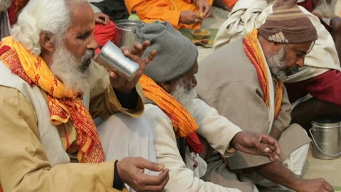 Sadhus eating the food offered by devotees as a donation Stock Footage 132889874