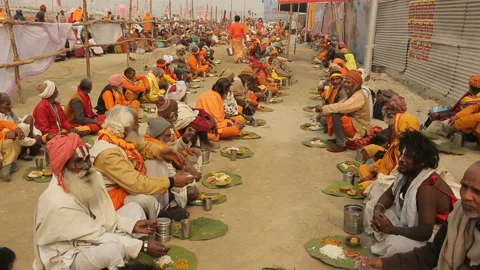 Sadhus eating the food offered by devotees as a donation Stock Footage 132890136