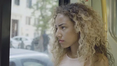 Sadness on the bus: pensive young woman sitting alone and depressed on the bus Stock Footage