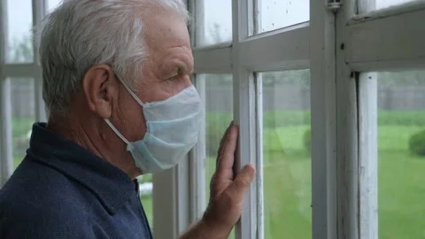 Sadness Elderly Old Caucasian Man In Medical Mask Sadness Looks Out Window Video stock 134480409