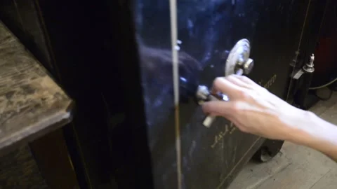 Safe, antique, with handle and lock, opened by woman's hand and book removed Stock Footage 222434732