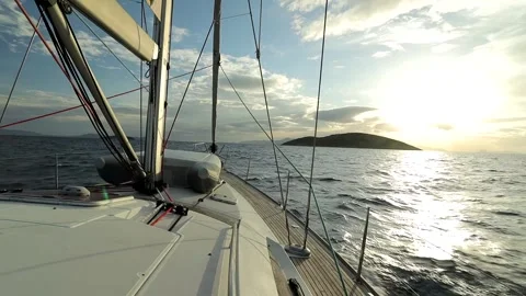Safe dinghy on the deck of a sailboat sailing on a wavy sea at sunset Stock Footage 277569660