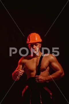 In safe keeping. Muscular man with nail. Construction worker or builder with Stock Photos