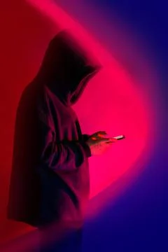 Safe storage of personal data on a smartphone. Shrouded in darkness hooded fi Stock Photos